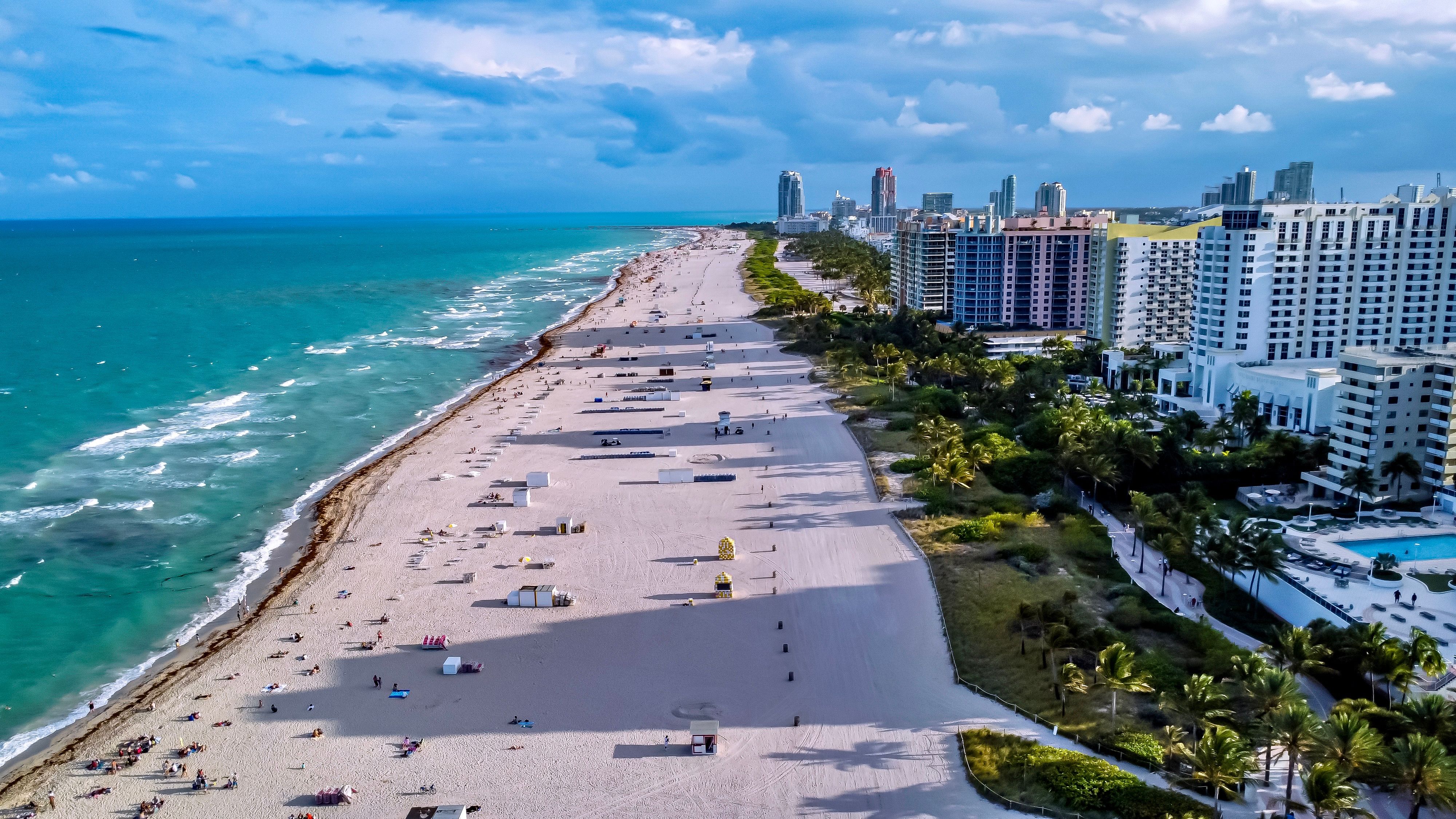 Turquoise ocean, sandy coastline and waterfront skyline at Miami Beach, Florida